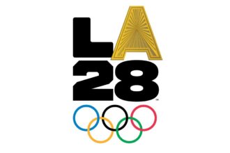 LA 2028 Olympic logo: bold black '2028' with a gold 'A' perched on top and the five interlocking Olympic rings below.