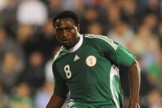Soccer player in a green Nigeria style jersey with number 8 sprinting on the field amid a blurred crowd  trybalnews
