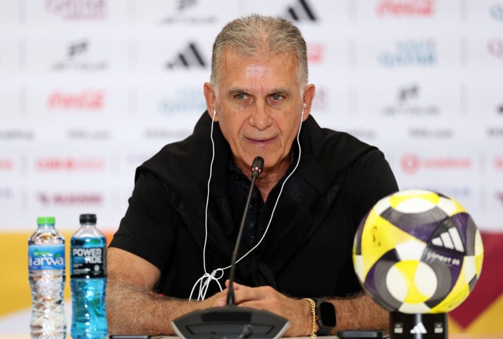 Carlos Queiroz dressed in a black hoodie speaks to the media during a post match press conference after the FIFA Arab Cup 2025 Group B match between Oman and Comoros  trybalnews