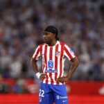 Atlético Madrid footballer wearing the red and white striped jersey hands on hips during a match  trybalnews