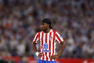 Atlético Madrid footballer wearing the red and white striped jersey hands on hips during a match  trybalnews