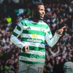 Celtic FC player in green and white hoops celebrating pointing with his right hand while the crowded stadium cheers behind him  trybalnews