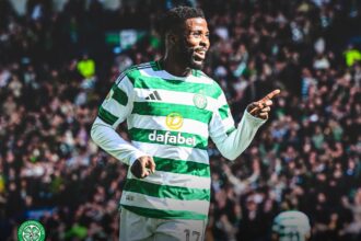 Celtic FC player in green and white hoops celebrating pointing with his right hand while the crowded stadium cheers behind him  trybalnews