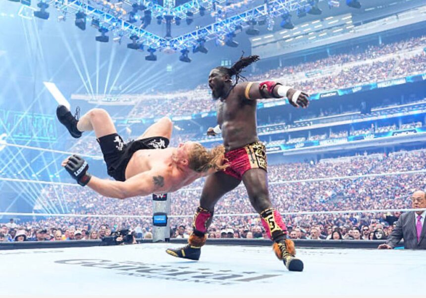 Two muscular wrestlers clash in a packed arena one fighter flips backward as the other delivers a kick  trybalnews