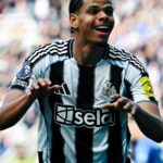 Newcastle United player celebrating with arms outstretched smiling in black and white striped kit on a crowded stadium backdrop  trybalnews