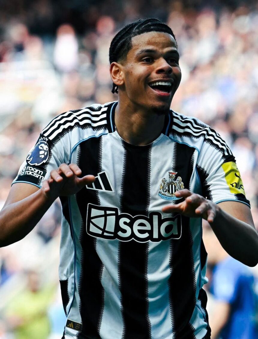 Newcastle United player celebrating with arms outstretched smiling in black and white striped kit on a crowded stadium backdrop  trybalnews