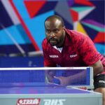 Nigerian table tennis player in a maroon GEWO jersey crouches at the net focused during a match  trybalnews