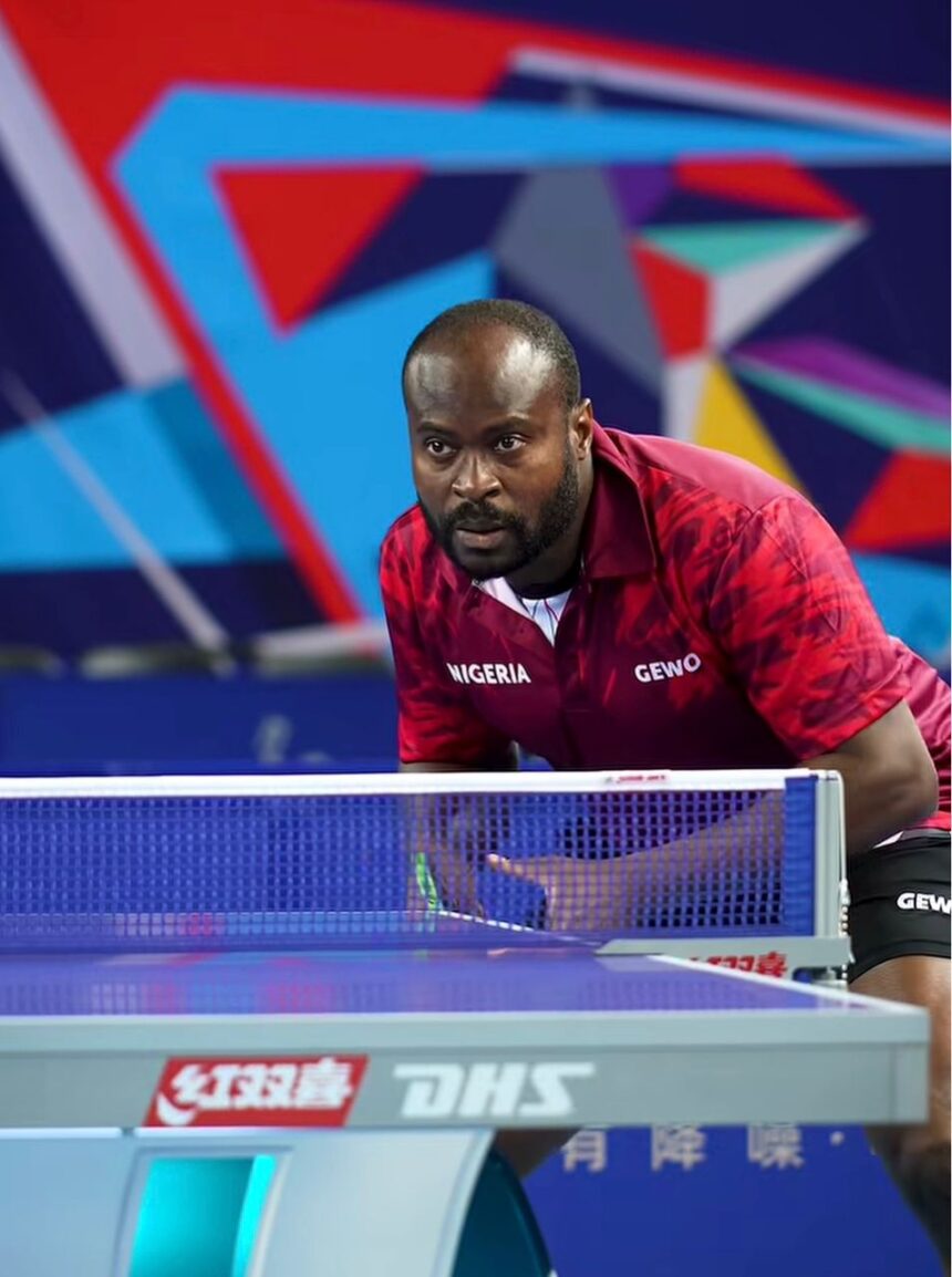Nigerian table tennis player in a maroon GEWO jersey crouches at the net focused during a match  trybalnews