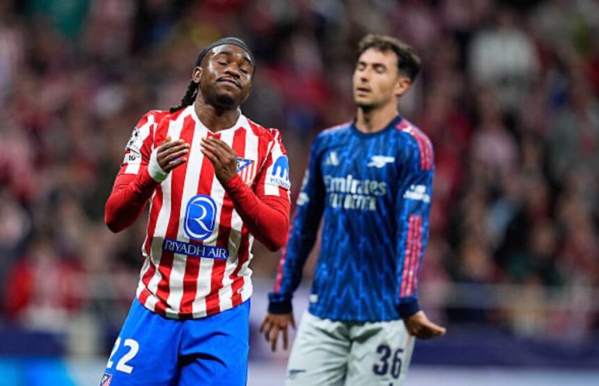 Soccer players on a stadium field foreground player in a red and white striped jersey raises his hands and looks satisfied while a blue jersey opponent watches in the background  trybalnews