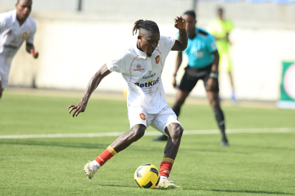 Ikorodu City vs Wikki Tourists Nigeria Premier Football League Trybal News Soccer player in a white kit dribbling a yellow ball on a green field with teammates and a referee in the background trybalnews