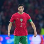 Moroccan national team footballer in red jersey with number 2 on the front standing on the field  trybalnews