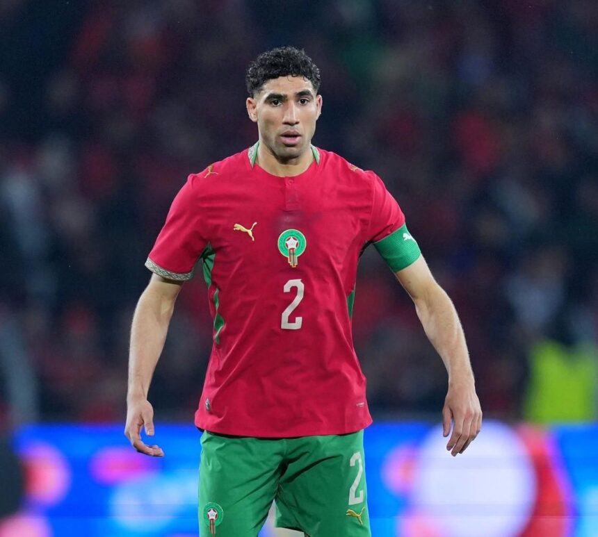 Moroccan national team footballer in red jersey with number 2 on the front standing on the field  trybalnews