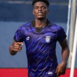 Male athlete in a blue gradient soccer jersey runs forward on a field Sporting crest visible on chest  trybalnews