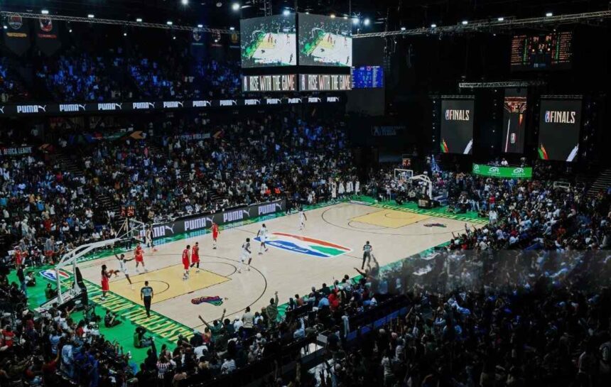 Packed basketball arena during a live game players on court sponsor banners along the sidelines  trybalnews