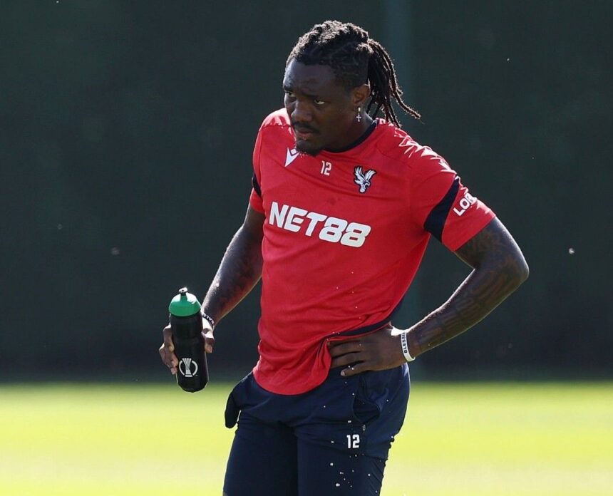 Soccer player in a red training top with NET88 holding a water bottle during practice  trybalnews