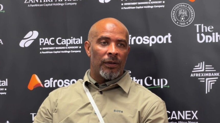 Eric Chelle in a beige shirt sits at a press backdrop leaning backwards during a post match interview  trybalnews