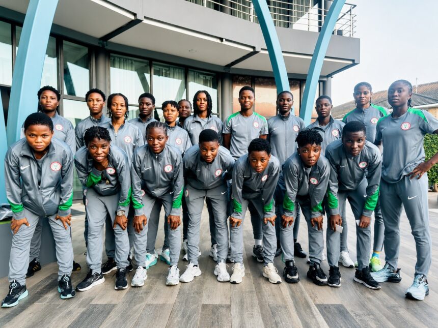 Team of young athletes in gray and green tracksuits posing for a group photo outdoors in front of a modern building with blue arches outside  trybalnews