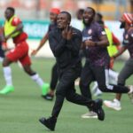 Man in black athletic wear sprints across a soccer field as teammates celebrate in the background  trybalnews