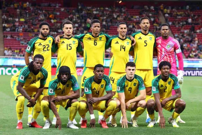 Jamaica national soccer team posing for a pre match team photo on a soccer field in yellow jerseys with green sleeves  trybalnews