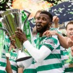 Celtic FC players celebrate victory lifting a tall silver trophy with green ribbons and confetti flying around  trybalnews