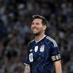 Soccer player in an Argentina blue black jersey with captains armband smiling on the field  trybalnews