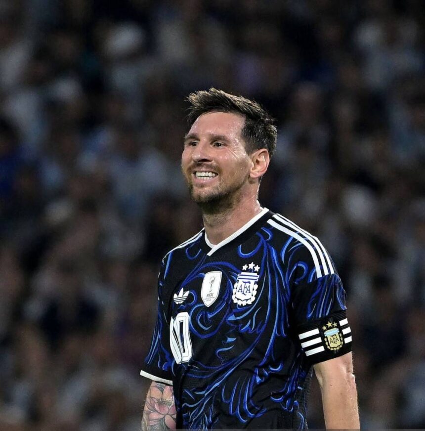 Soccer player in an Argentina blue black jersey with captains armband smiling on the field  trybalnews