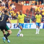 Soccer player in a yellow jersey controls the ball on the green field while a crowd watches from the stands  trybalnews