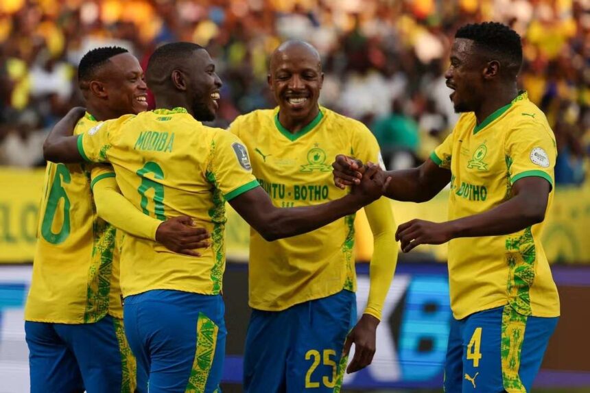 Soccer players in yellow jerseys celebrate together on the field arms around each other smiling  trybalnews
