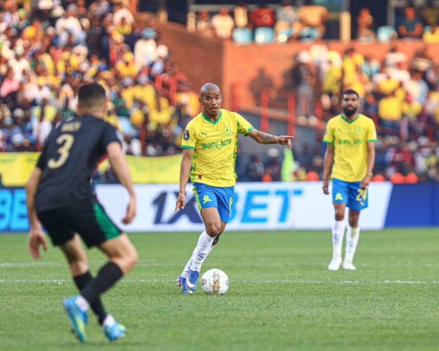 Soccer player in a yellow jersey controls the ball on the green field while a crowd watches from the stands  trybalnews