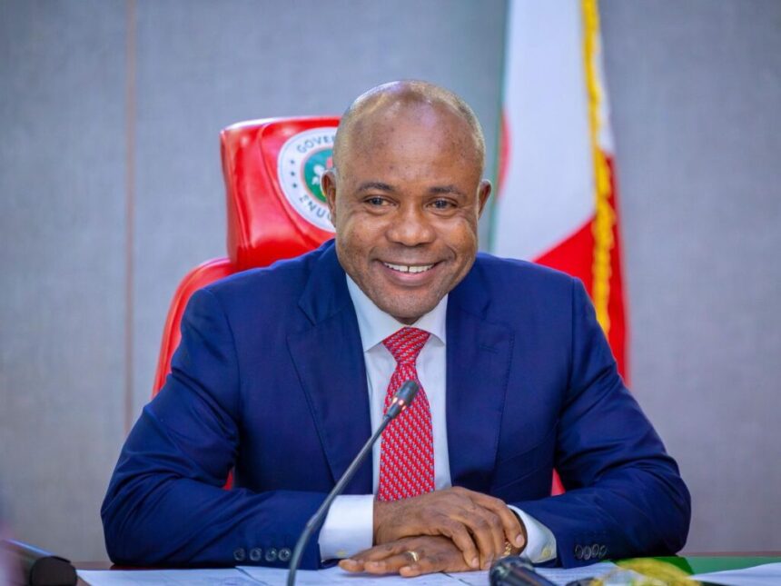 Official seated at a desk during a meeting microphone in front flag and government seal visible behind him  trybalnews