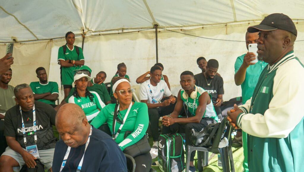 WhatsApp Image 20260502 at 063934 Trybal News Group of Nigerian athletes in green sportswear listening to a coach under a white tent canopy man speaking to the group at the front trybalnews