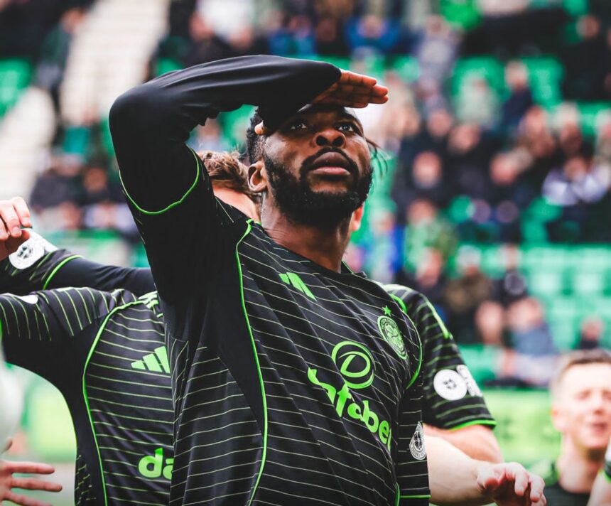Soccer player in a black and green striped jersey shields his eyes with his hand while looking upward stadium crowd in the background  trybalnews