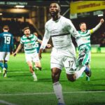 Soccer player in a white kit number 17 runs toward the camera as teammates celebrate in the background on a green pitch  trybalnews