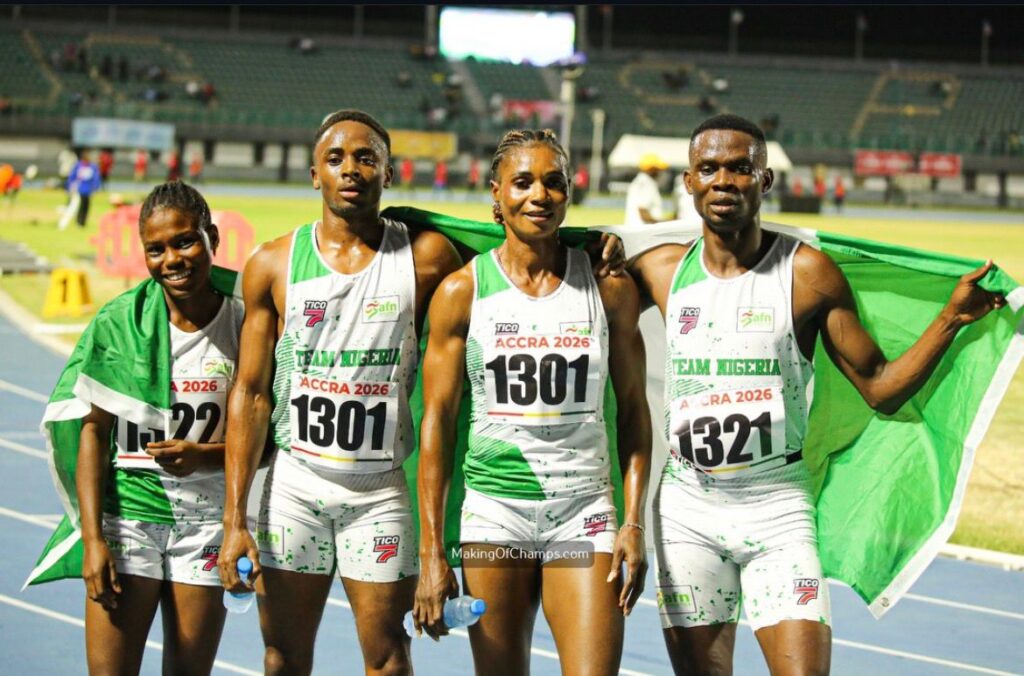 Four Nigerian track athletes on a blue track posing with a green flag after a race bibs read ACCRA 2026 Team Nigeria  trybalnews