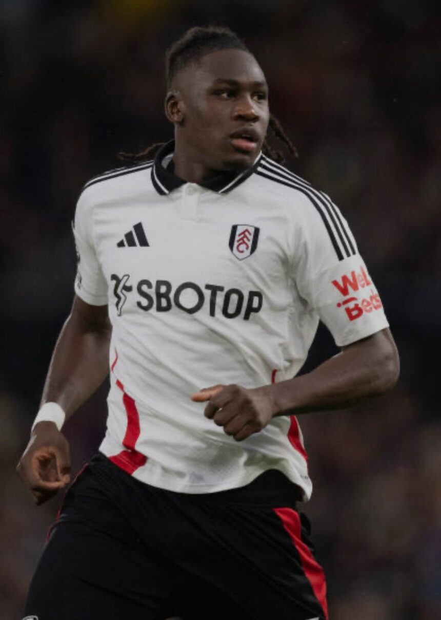 Footballer in a white Fulham kit sprinting during a match with SBOTOP sponsor logo visible on the front  trybalnews