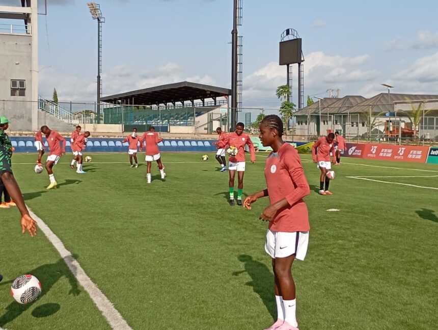 Soccer training on a sunny field with female players in red jerseys and white shorts handling balls statuesque on green turf  trybalnews