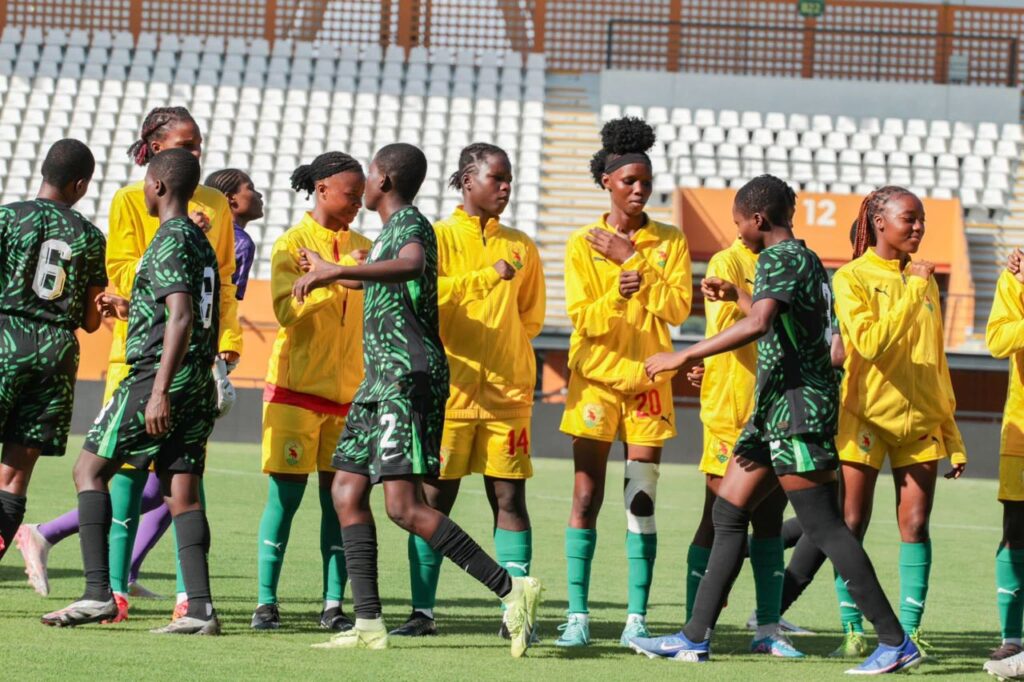 Womens soccer players in yellow and green uniforms shake hands on a sunny stadium field after a match forming a line  trybalnews