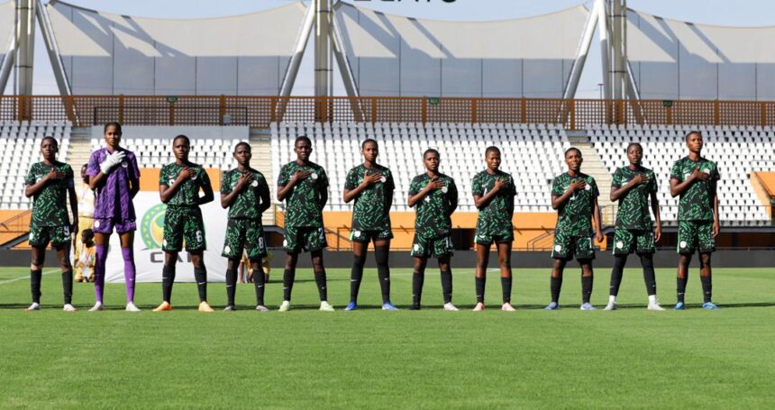 Soccer team lined up on a grassy field with hands over their hearts wearing green uniforms in a stadium   trybalnews