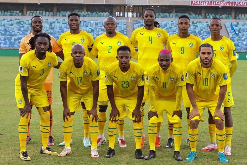 Senegal national football team players in yellow kits pose for a group photo on a soccer field with empty stadium seats behind them  trybalnews