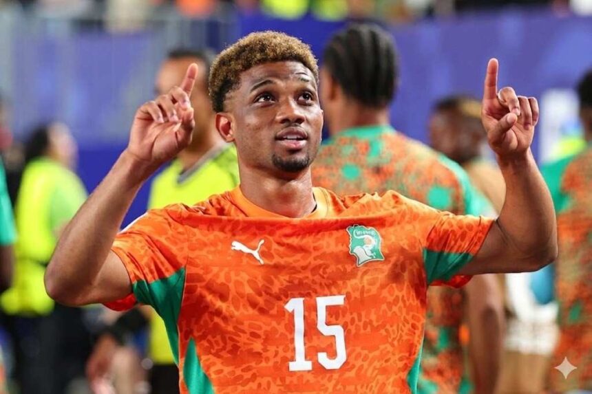 Amad Diallo in an orange jersey with the number 15 raising both arms and pointing upward with his index fingers in celebration  trybalnews