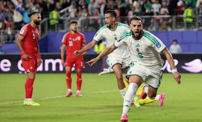 Amine Gouiri in Algerias white 9 jersey with green stripes runs forward with mouth open and arms outstretched in celebration He wears white shorts socks with FAF and pink football boots Behind him an Algeria teammate in the same kit runs and shouts with his right fist clenched Two Jordan players in red 5 and 11 jerseys stand dejected in the background The match is Jordan vs Algeria at San Francisco Bay Area Stadium FIFA World Cup 2026 Group J June 22 2026 Santa Clara California A packed stadium crowd is blurred behind a blue advertising board  trybalnews