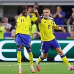 Sweden forward Anthony Elanga wearing yellow 11 jersey with blue shoulders blue shorts yellow socks and a black headband celebrates with teammate Gustaf Lagerbielke 2 Elanga is on the left with his mouth open shouting right arm raised and Lagerbielkes arm around his shoulder Lagerbielke wearing yellow 2 jersey and blue shorts runs beside him with his mouth open and left arm out Both wear matching yellow Adidas kits with Sweden crest and blue shorts FIFA World Cup 2026 Group F match between Japan and Sweden at Dallas Stadium Arlington Texas on June 25 2026 Blurred fans react in the background  trybalnews