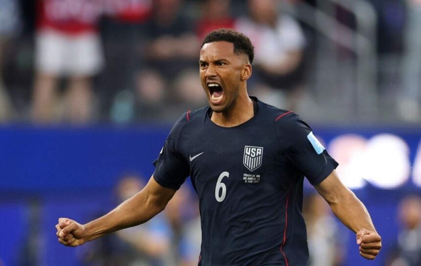USA defender Auston Trusty wearing navy blue 6 Nike jersey with white USA crest and red trim celebrates with a roar He has short curly hair both fists clenched and arms spread wide with an intense expression FIFA World Cup 2026 Group D match between Türkiye and USA at Los Angeles Stadium Inglewood California on June 25 2026 Blurred crowd and blue stadium boards in the background  trybalnews