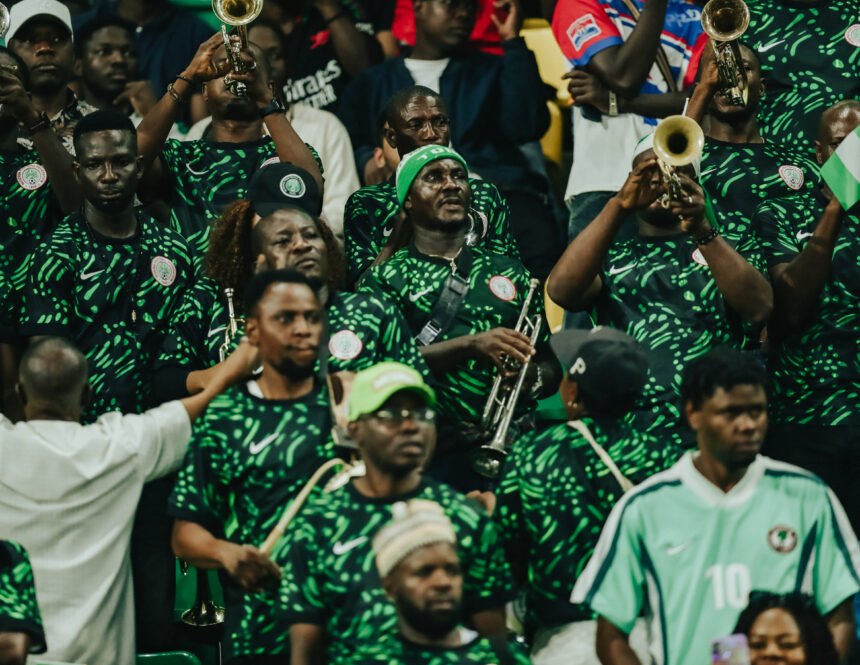 Crowd of band members in green patterned jerseys playing brass instruments at a stadium like event  trybalnews