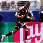 Male soccer player in a maroon jersey 16 celebrating with clenched fists on the pitch  trybalnews