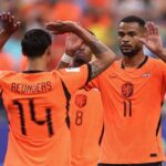 Netherlands players Cody Gakpo wearing orange jersey number 11 and Tijjani Reijnders wearing orange jersey number 14 celebrate together on the pitch Gakpo faces the camera with both hands raised while Reijnders has his back to camera with arms up high Both wear orange Netherlands kits with the Dutch crest A third teammate in jersey number 8 is blurred in the background Fans in orange fill the stadium stands behind them Match was FIFA World Cup 2026 Group F Netherlands vs Sweden at Houston Stadium Houston Texas on June 20 2026  trybalnews