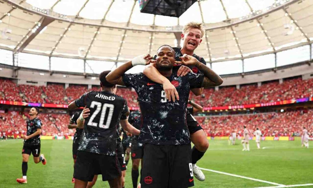Cyle Larin of Canada celebrates with teammate Luc de Fougerolles after scoring vs Qatar at FIFA World Cup 2026 BC Place Vancouver June 18 2026 Both wear black Canada kits in a packed stadium  trybalnews
