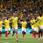 Colombia defender Daniel Muñoz wearing yellow jersey with blue 2 and white shorts celebrates with right index finger raised Five Colombia teammates in matching yellow jerseys and red socks run alongside him near the goalpost Crowd in yellow fills the stadium background during FIFA World Cup 2026 Group K match between Colombia and Congo DR at Guadalajara Stadium Zapopan Mexico on June 23 2026  trybalnews