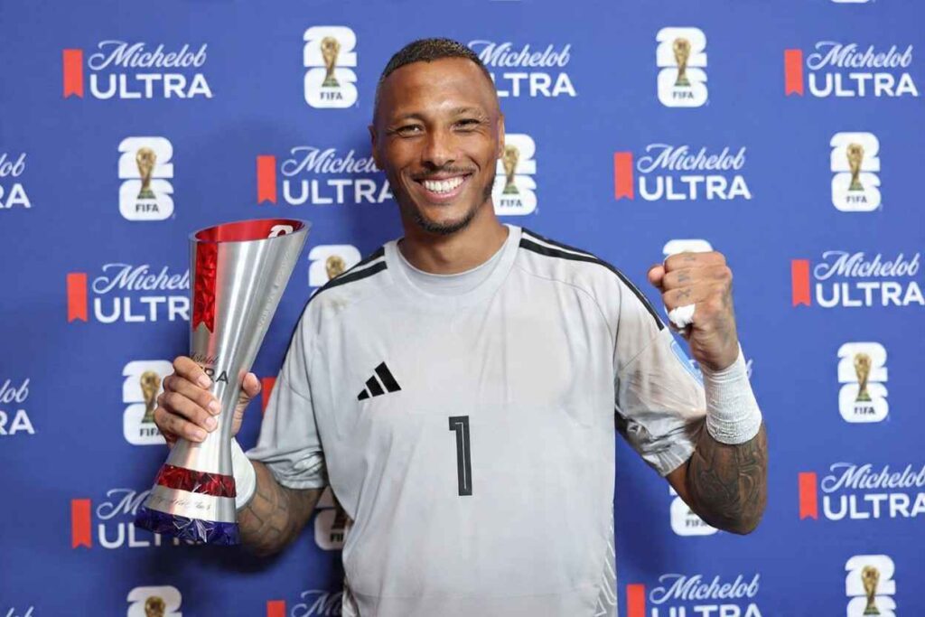 Eloy Room Trybal News Curaçao goalkeeper Eloy Room wearing number 1 gray jersey smiles while holding the Michelob Ultra Player of the Match trophy and raising his fist He stands in front of a blue FIFA World Cup 2026 backdrop at Kansas City Stadium on June 20 2026 after the Group E match vs Ecuador trybalnews