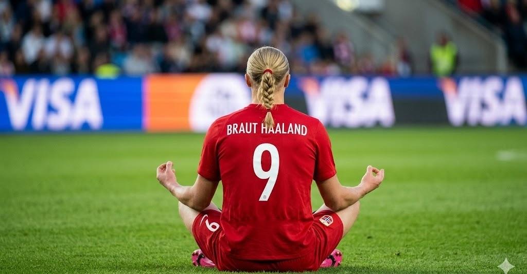 Erling Haaland of Norway in red jersey sits crosslegged on grass back to camera jersey reads aposBRAUT HAALANDapos and number 9 meditating on the field with stadium crowd in the background Visa boards visible  trybalnews